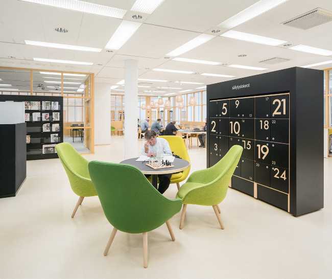 zona relax lettura poltrone verde e librerie nere